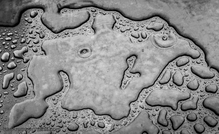 Water (plus two raindops landing) on an aluminum table outside a coffee shop in Hanau, east of Frankfurt, July 9. A very rainy day it was...
